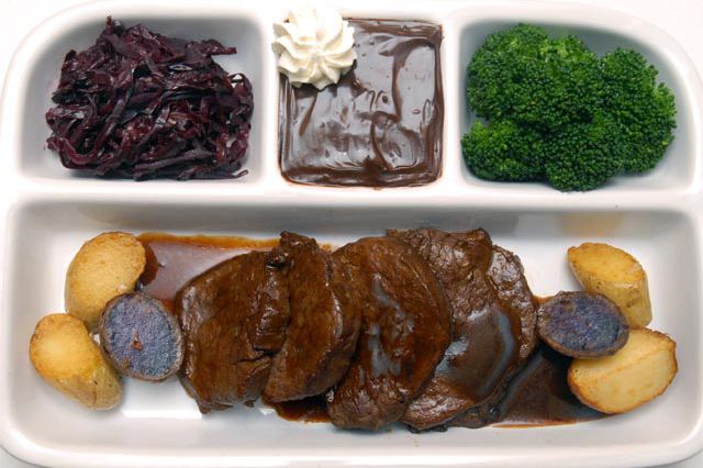 Pot Roast slow-cooked in Burgundian Pinot Noir. The eye of the roast is served with a trio of baby potatoes, including purple Peruvian, Russian banana and red bliss.  Side dishes: Red cabbage made in a blend of red vinegar, brown sugar and fresh steamed broccoli. Dessert is Vahlrona chocolate pudding with a touch of whipped cream. 